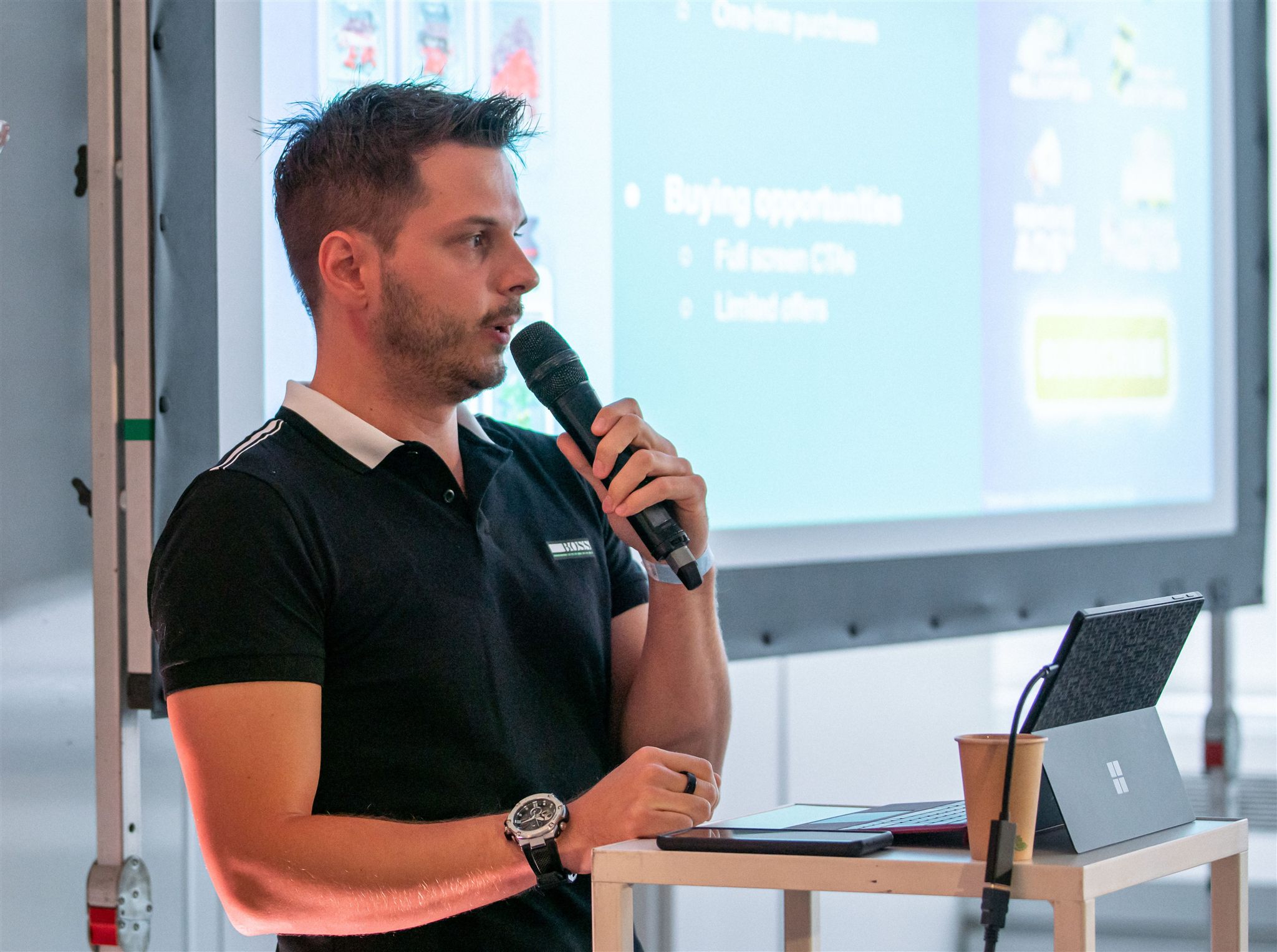 Louis speaking into a microphone during a presentation at Game Camp