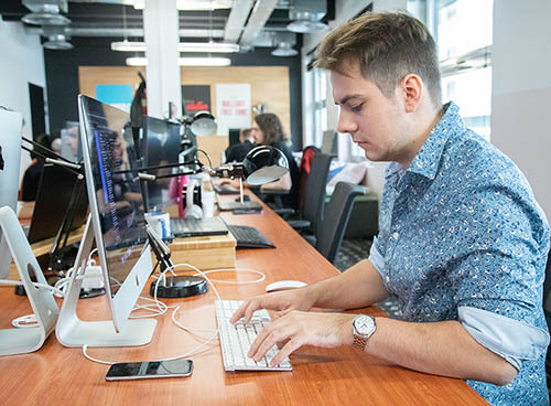 An 8SEC developer working at his desk